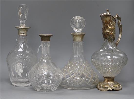 Three cut glass decanters with silver collars (one stopper deficient) and plate-mounted cut glass claret jug
